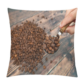 Personality  A Man Holds Roasted Coffee Grains In A Tablespoon On A Background Of A White Plate And Dark Wood Pillow Covers