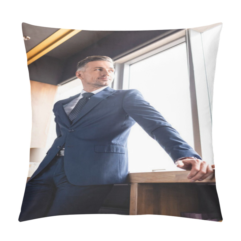 Personality  low angle view of smiling businessman in suit looking through window  pillow covers