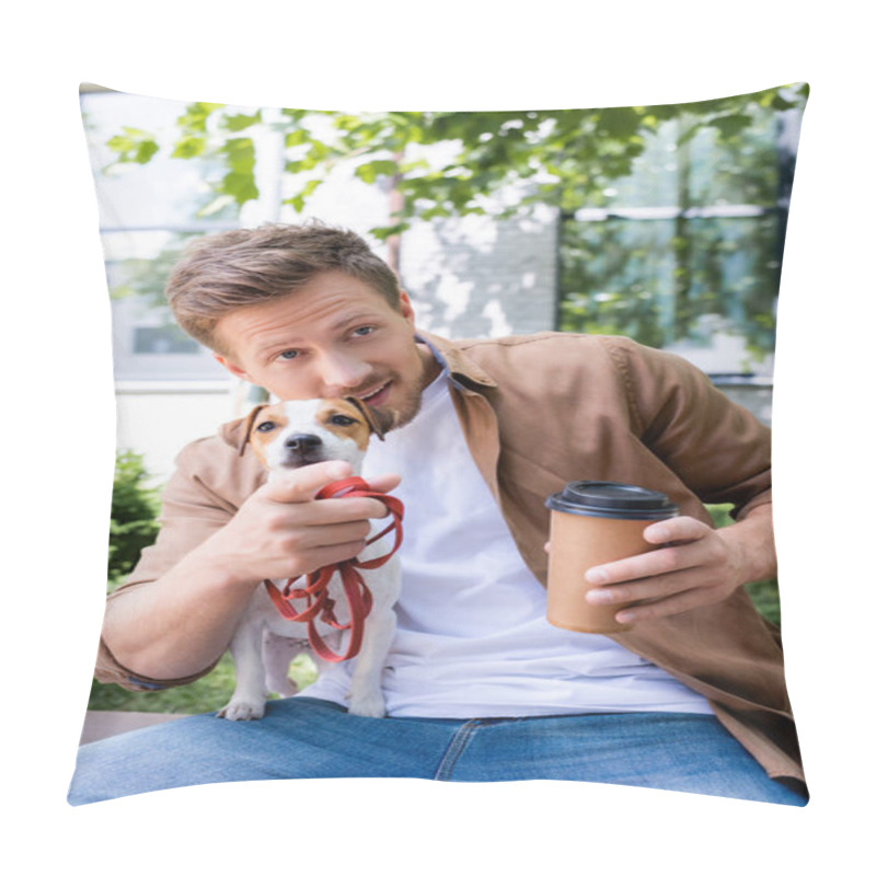 Personality  young man with jack russell terrier dog holding coffee to go and pointing with finger while sitting on bench pillow covers