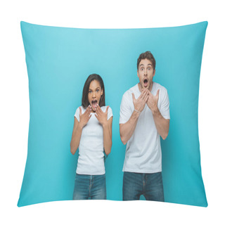 Personality  Shocked Interracial Couple Holding Hands Near Faces With Open Mouths While Looking At Camera On Blue Background Pillow Covers