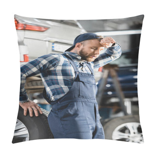 Personality  Exhausted Mechanic Holding Hand Near Forehead While Standing Near Car Wheel With Closed Eyes On Blurred Background Pillow Covers