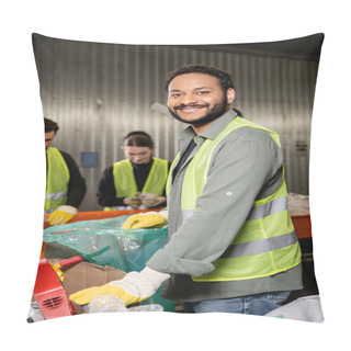 Personality  Cheerful Indian Sorter In Protective Gloves And Safety Vest Looking At Camera While Standing Near Plastic Bag, Blurred Conveyor And Colleagues Working In Waste Disposal Station, Recycling Concept Pillow Covers