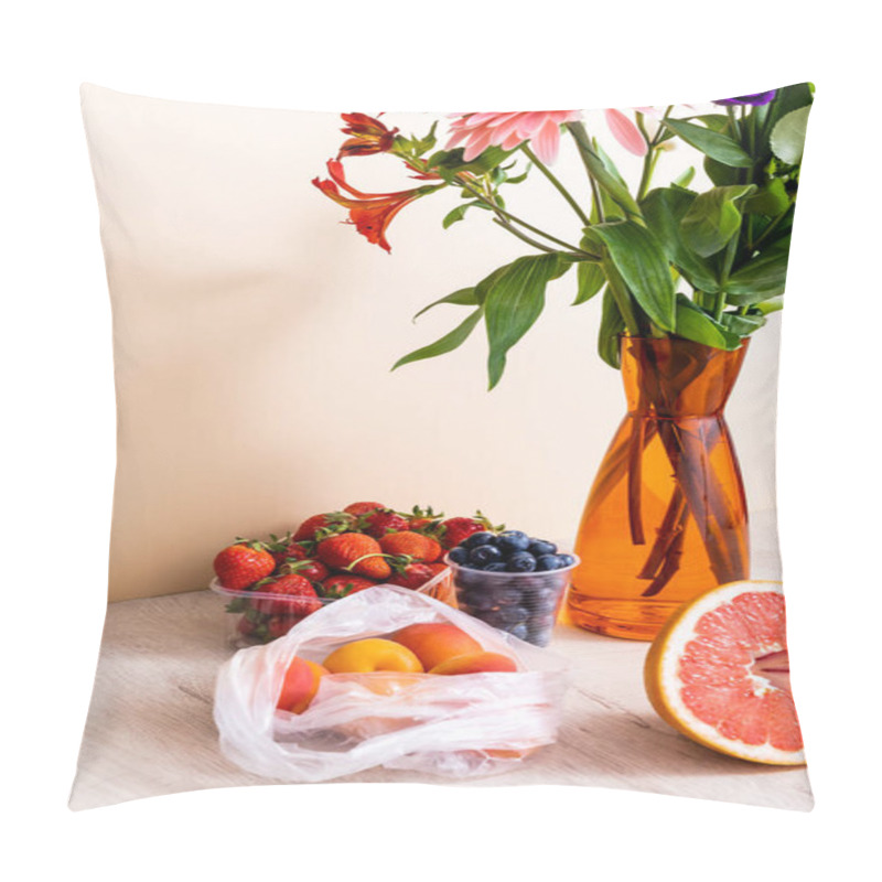 Personality  floral and fruit composition with bouquet in vase, berries, grapefruit and apricots on wooden surface on beige background pillow covers