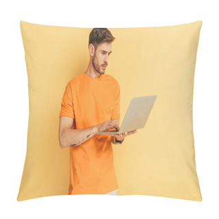 Personality  Attentive Young Man In Orange T-shirt Using Laptop On Yellow Background Pillow Covers