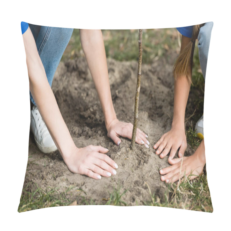 Personality  cropped view of mother and daughter planting young tree in forest, ecology concept pillow covers