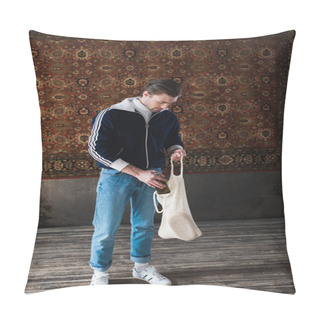 Personality  Man In Old School Clothes Putting Bottle Of Beer Into String Bag In Front Of Rug Hanging On Wall Pillow Covers