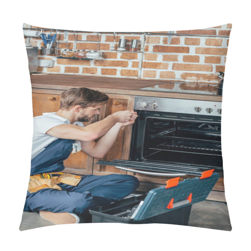Personality  high angle view of young repairman fixing oven in kitchen pillow covers