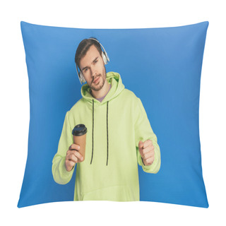 Personality  Dreamy Young Man In Wireless Headphones Holding Coffee To Go And Looking At Camera On Blue Background Pillow Covers