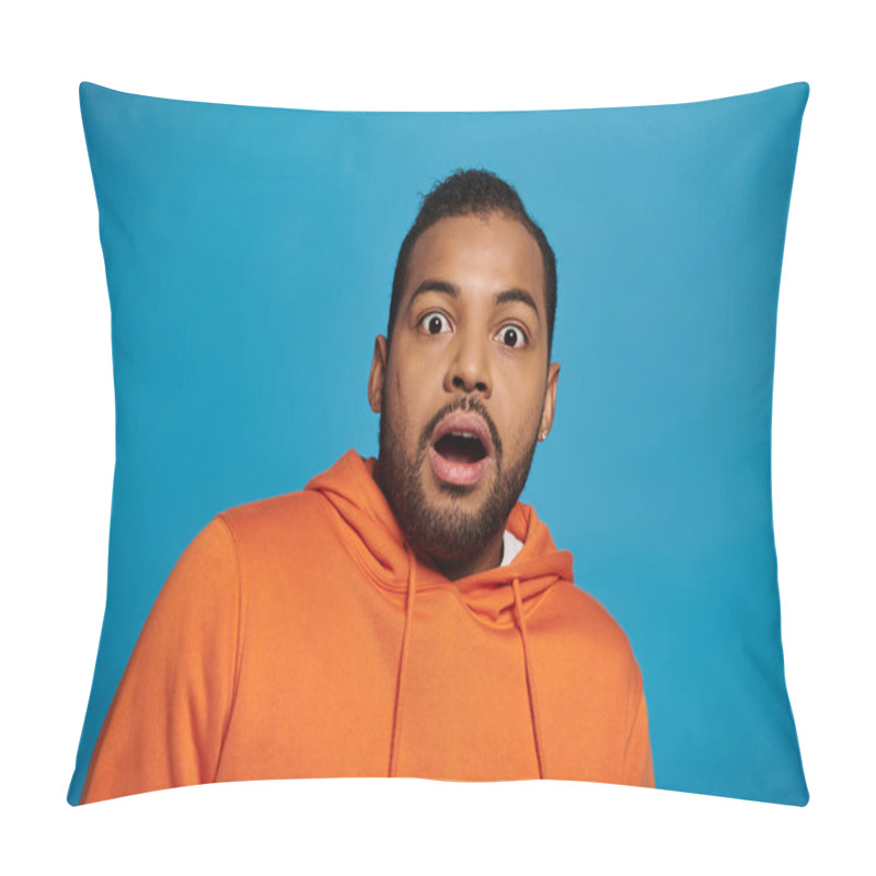 Personality  attractive african american man in orange outfit was surprised against blue background pillow covers