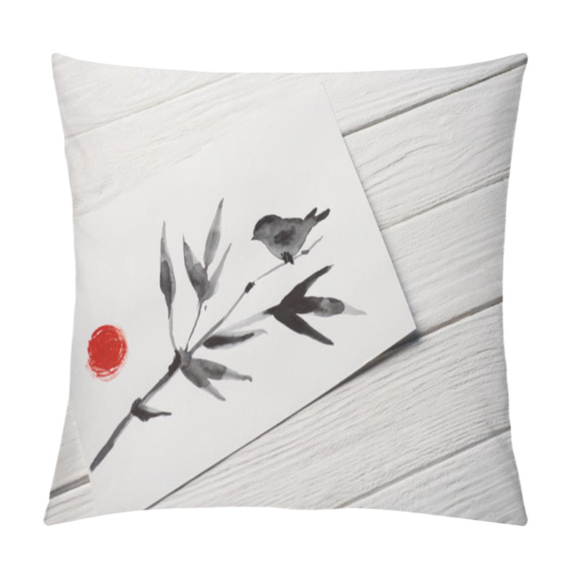 Personality  High angle view of paper with japanese painting with bird on branch and sun on wooden background pillow covers