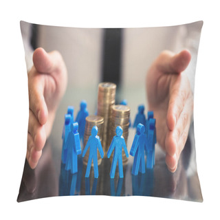 Personality  Businessperson's Hand Protecting Blue Human Figures Surrounding Stacked Golden Coins Over Desk Pillow Covers