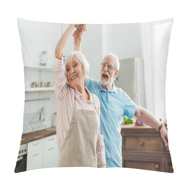 Personality  Selective focus of smiling senior couple dancing in kitchen pillow covers