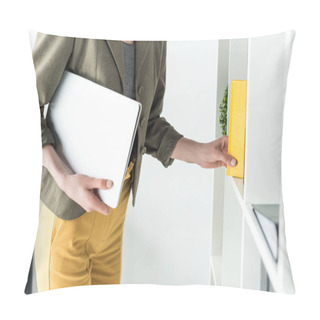 Personality  Cropped Shot Of Businesswoman Holding Laptop And Taking Book From Shelf In Office Pillow Covers