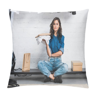 Personality  Smiling Female Designer Sitting With Stack Of White T-shirts And Paper Package In Clothing Design Studio Pillow Covers