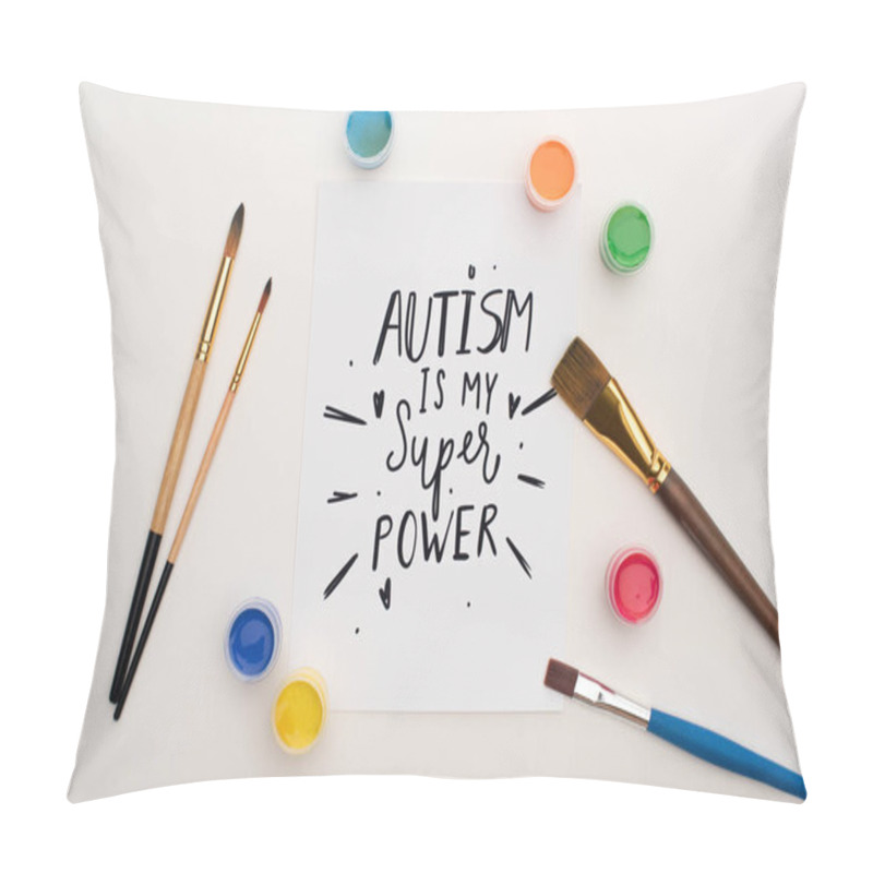 Personality  top view of paints, brushes and card with autism is my super power lettering on white pillow covers