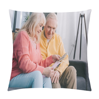 Personality  Happy Senior Couple Holding Envelope With Money While Sitting On Couch At Home Pillow Covers