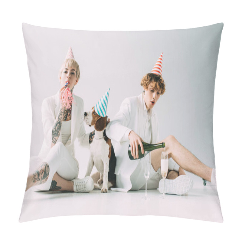 Personality  woman holding blower while man poring champagne in glasses while sitting near beagle dog on grey background pillow covers