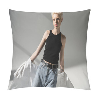 Personality  Tattooed Albino Woman In Black Tank Top And Jeans Taking Off White Shirt On Grey Background Pillow Covers