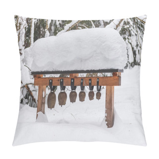 Personality  Old, Metal Alpine Cow Bells Of Various Sizes Hanging On A Wooden Structure. Trees And Path Covered With Snow. Pillow Covers