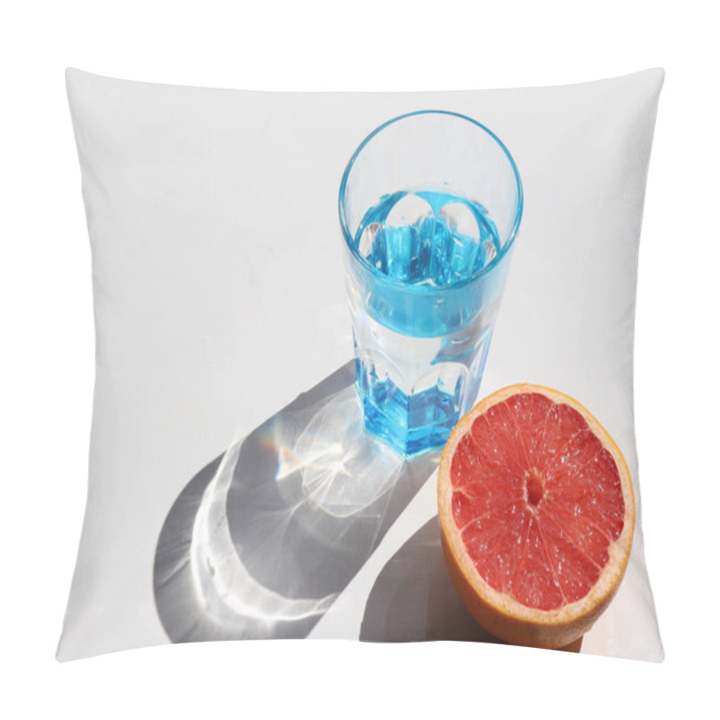 Personality  Summer still life with blue glass of cold water and half of grapefruit on white table background. Top view, copy space. Hard light, shadow pillow covers