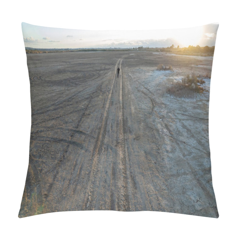Personality  Unrecognized person hiking on a deserted rural road at sunset in a dry lake. Concept of environmental ecological climate change. pillow covers