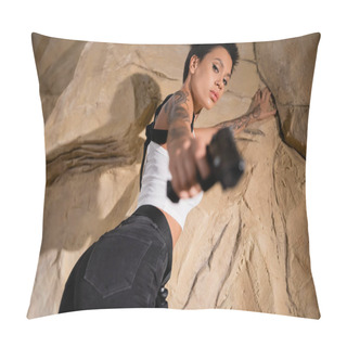 Personality  Low Angle View Of Tattooed Young Archaeologist In Sexy Outfit Aiming With Gun On Blurred Foreground  Pillow Covers