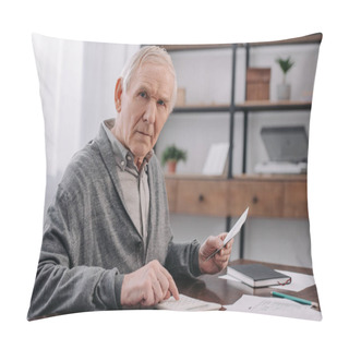 Personality  Senior Man Sitting At Table With Paperwork, Looking At Camera And Using Calculator While Counting Money  Pillow Covers