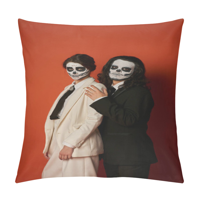 Personality  elegant couple in dia de los muertos makeup and elegant festive suits looking at camera on red pillow covers