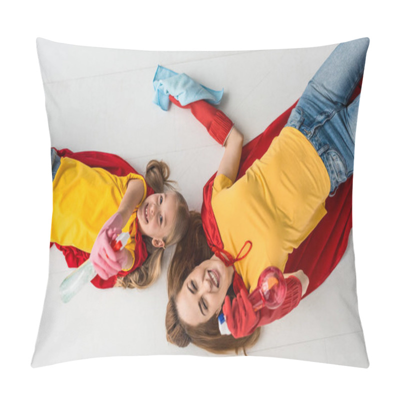 Personality  Top view of mother and kid in red capes and rubber gloves holding sprays and rug pillow covers