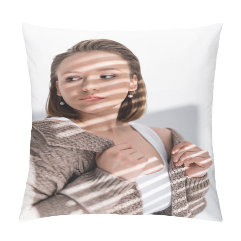 Personality  confident, attractive plus size girl touching sweater while looking away on white with sunlight and shadows pillow covers
