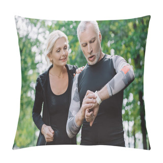 Personality  Surprised Mature Sportsman Looking At Fitness Tracker Near Smiling Sportswoman Pillow Covers