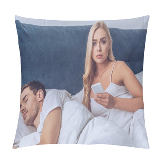 Personality  Unhappy Young Woman Holding Smartphone And Looking At Camera While Boyfriend Sleeping In Bed, Distrust Concept Pillow Covers