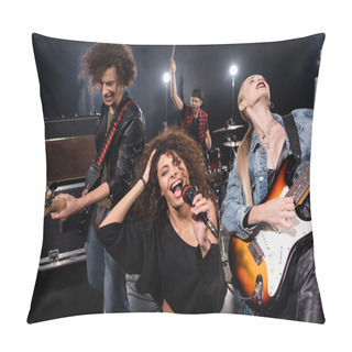 Personality  KYIV, UKRAINE - AUGUST 25, 2020:  Female Singer Of Rock Band With Microphone Singing Near Guitarists With Blurred Drummer On Background Pillow Covers