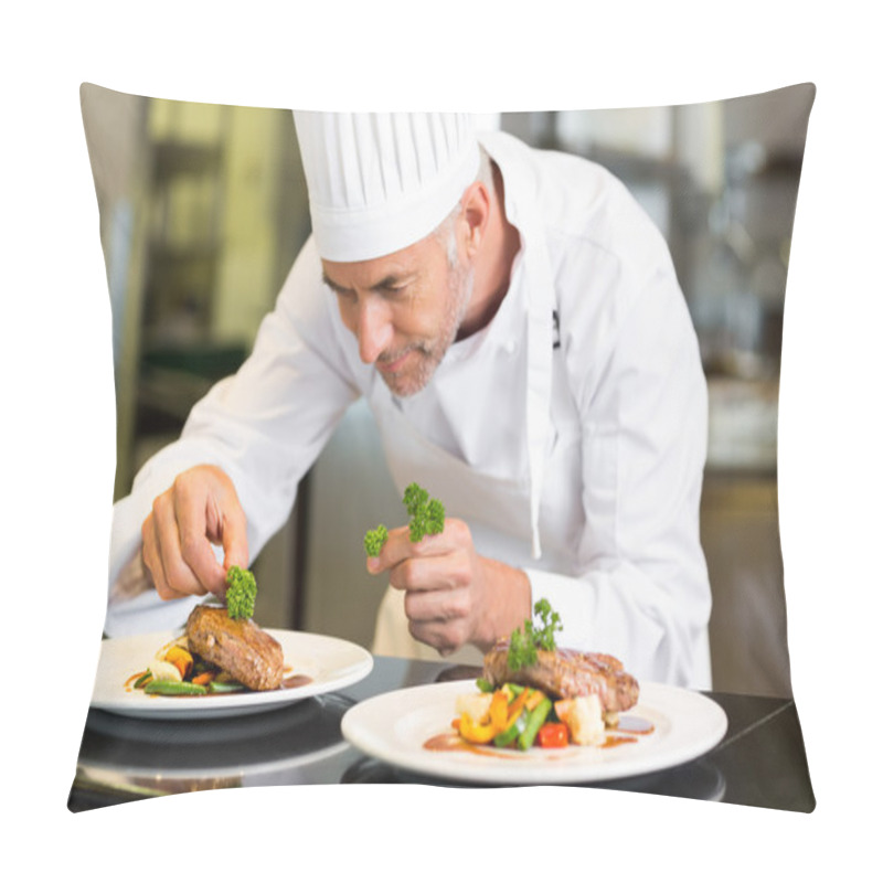 Personality  Concentrated male chef garnishing food in kitchen pillow covers