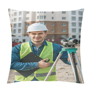 Personality  Surveyor Holding Clipboard And Digital Level And Smiling At Camera On Construction Site Pillow Covers