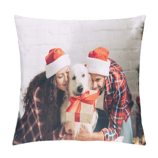 Personality  Smiling Young Couple In Santa Hats Embracing Cute Golden Retriever With Gift Box In Mouth At Home Pillow Covers