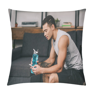 Personality  Mixed Race Man With Tattoo Holding Sport Bottle And Using Smartphone While Sitting On Chair In Living Room  Pillow Covers
