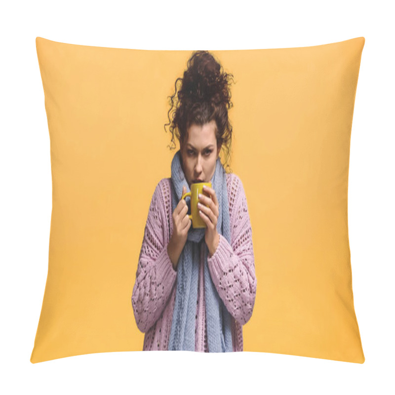 Personality  woman in knitted sweater and scarf holding cup of warm beverage isolated on orange pillow covers