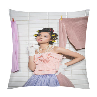 Personality  Asian Young Woman With Hair Curlers Standing In Pink Ruffled Top, Pearl Necklace And Gloves While Holding Cigarette Near Wet Laundry Hanging Near White Tiles, Housewife, Looking At Camera, Smoking  Pillow Covers