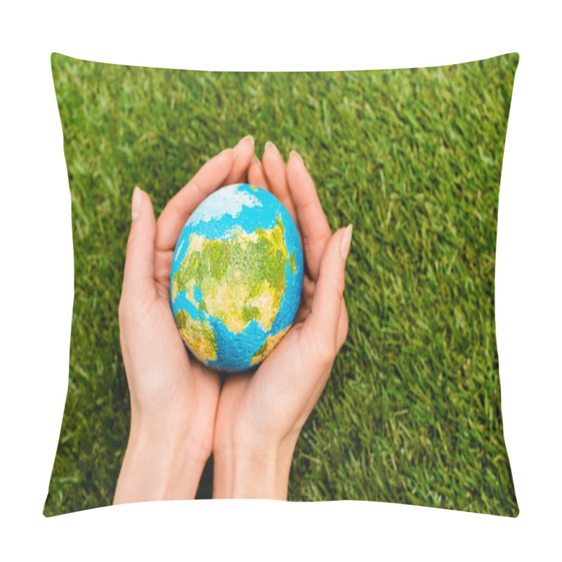 Personality  Cropped view of globe in female hands on green background, earth day concept pillow covers