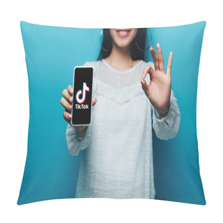 Personality  KYIV, UKRAINE - JULY 15, 2019: Cropped View Of Smiling Asian Woman In White Blouse Showing Ok Sign And Smartphone With Tiktok App On Blue Background Pillow Covers