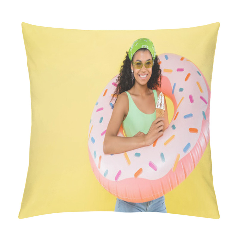 Personality  positive african american young woman standing with inflatable ring and ice cream cone isolated on yellow pillow covers