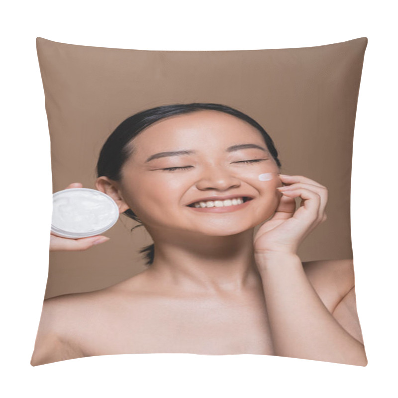 Personality  Pretty asian woman with naked shoulders holding cosmetic cream isolated on brown  pillow covers