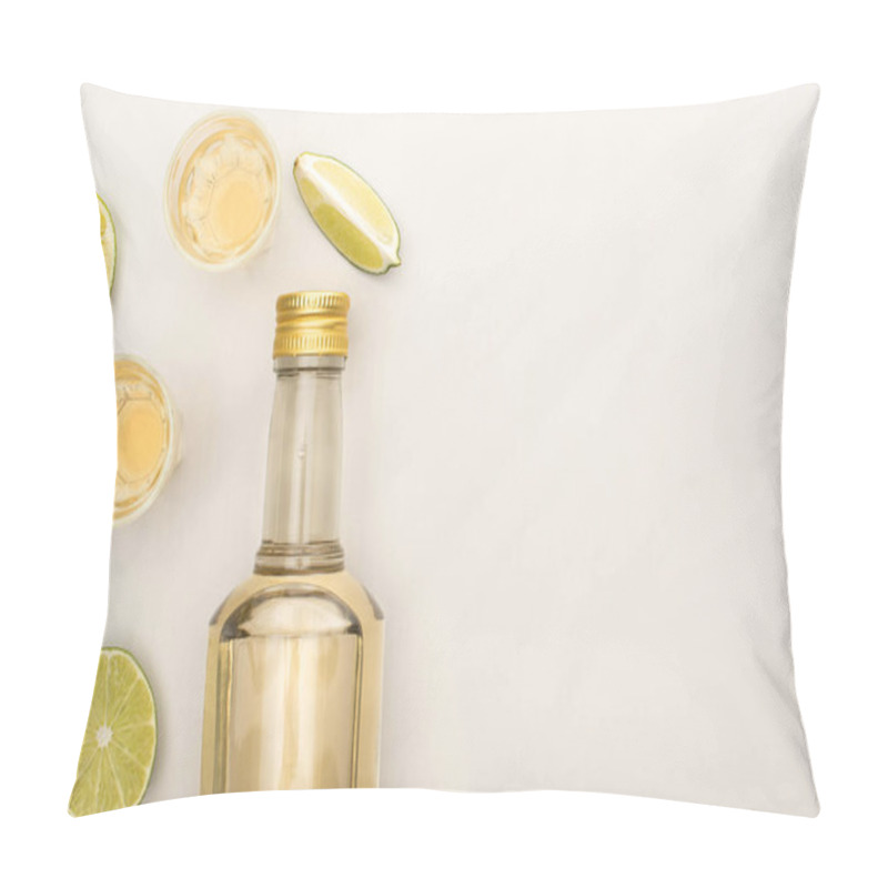 Personality  top view of golden tequila in bottle and shot glasses with lime on white marble surface pillow covers