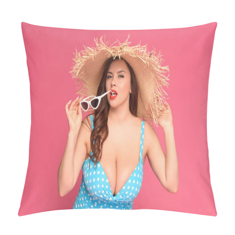 Personality  sexy young woman in swimsuit and straw hat biting sunglasses and looking at camera isolated on pink  pillow covers