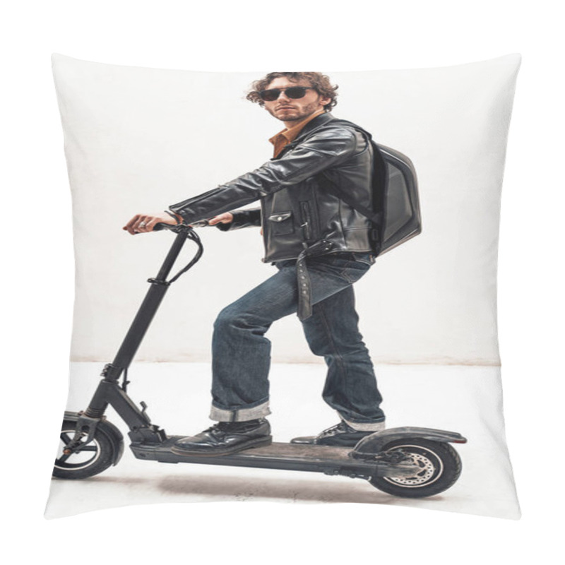 Personality  Assertive and rich young man posing on a scooter in a bright studio, looking cool pillow covers