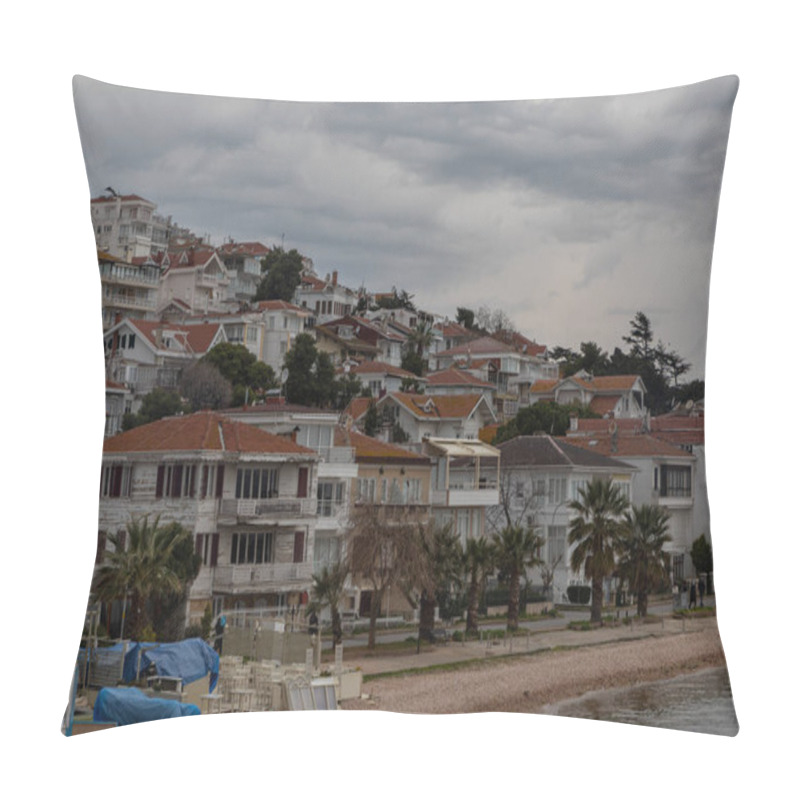 Personality  View from the sea on the island of Heybeliada in Istanbul. The slope shore is covered with many white summer cottages with brown tiled roofs. Beach with pebbles. Dramatic grey clouds in a stormy sky pillow covers