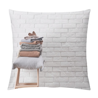 Personality  Stack Of Clean Bed Sheets And Pillow On Stool Near White Brick Wall. Space For Text Pillow Covers