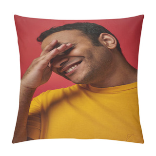 Personality  Shy Indian Man In Yellow T-shirt Smiling And Covering Eyes With Hand On Red Background In Studio Pillow Covers