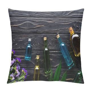 Personality  Colored Bottles Of Natural Herbal Essential Oils And Violet Flowers On Wooden Surface  Pillow Covers